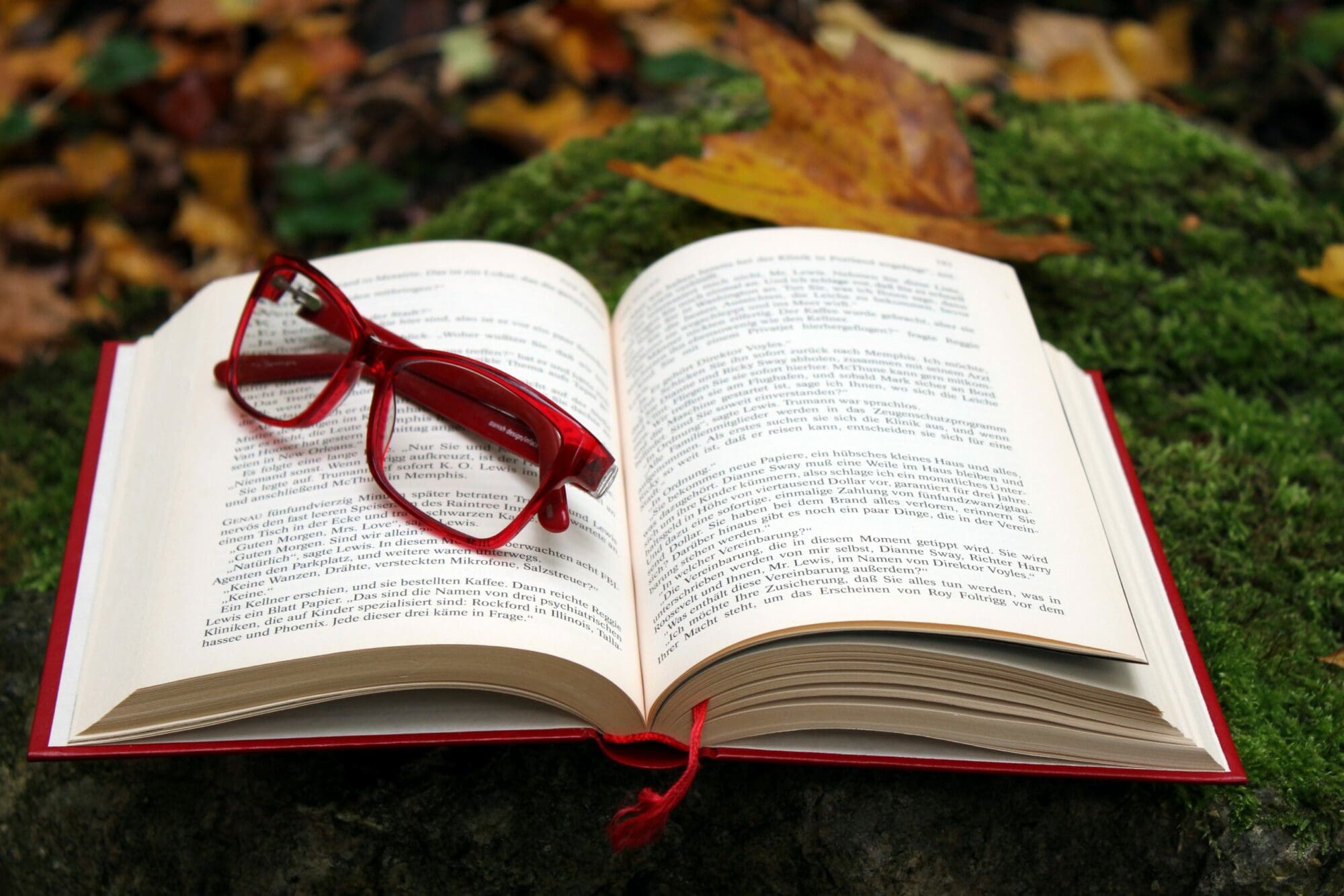 glasses on open book on grass
